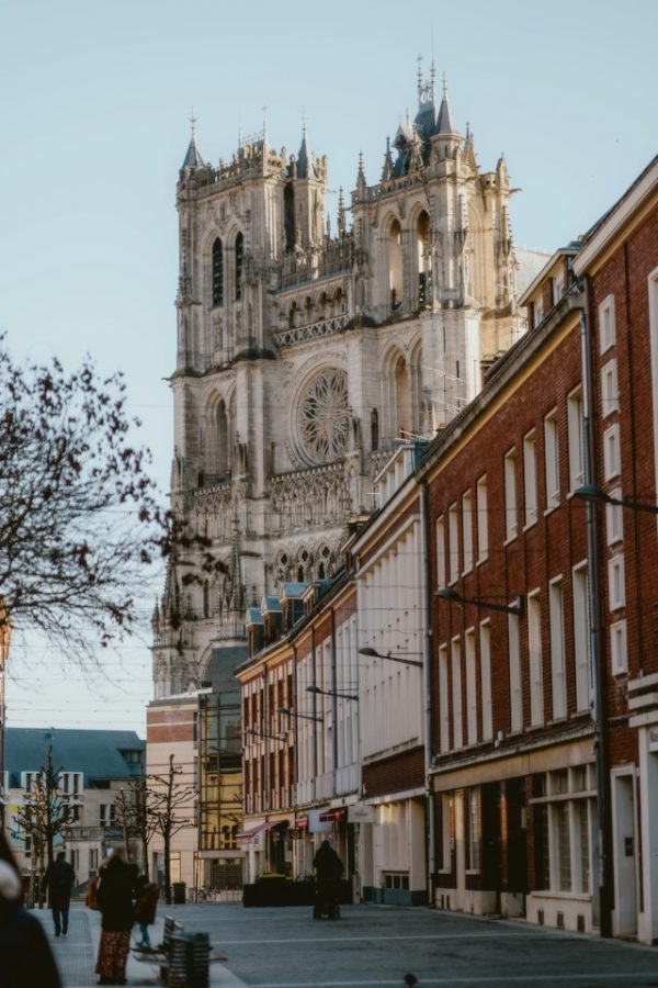 Rue du centre-ville d’Amiens avec la cathédrale Notre-Dame en arrière-plan et ses tours gothiques emblématiques