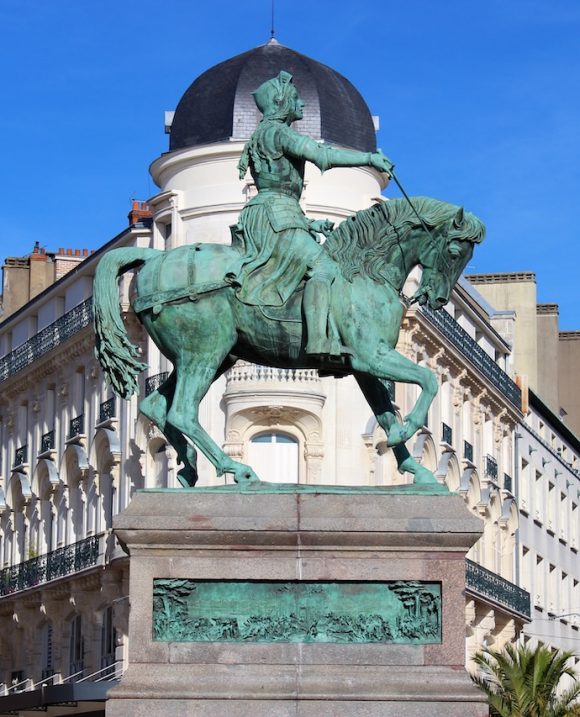 Statue équestre de Jeanne d’Arc à Orléans sur fond d’architecture classique et ciel bleu