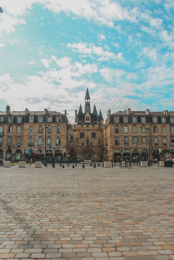 Porte Cailhau à Bordeaux sur une place pavée, monument médiéval emblématique du centre historique sous un ciel bleu