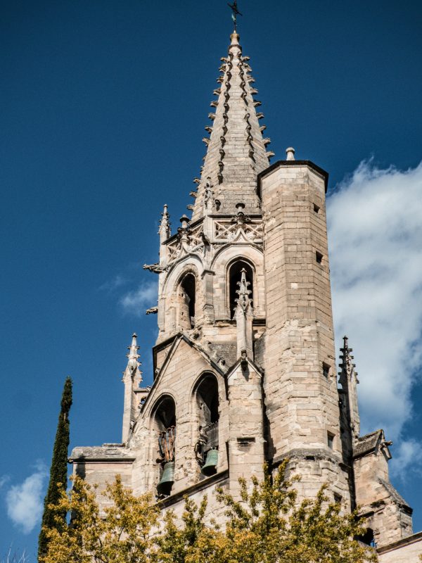 Clocher de la cathédrale Notre-Dame des Doms d’Avignon, architecture médiévale en pierre sous un ciel bleu